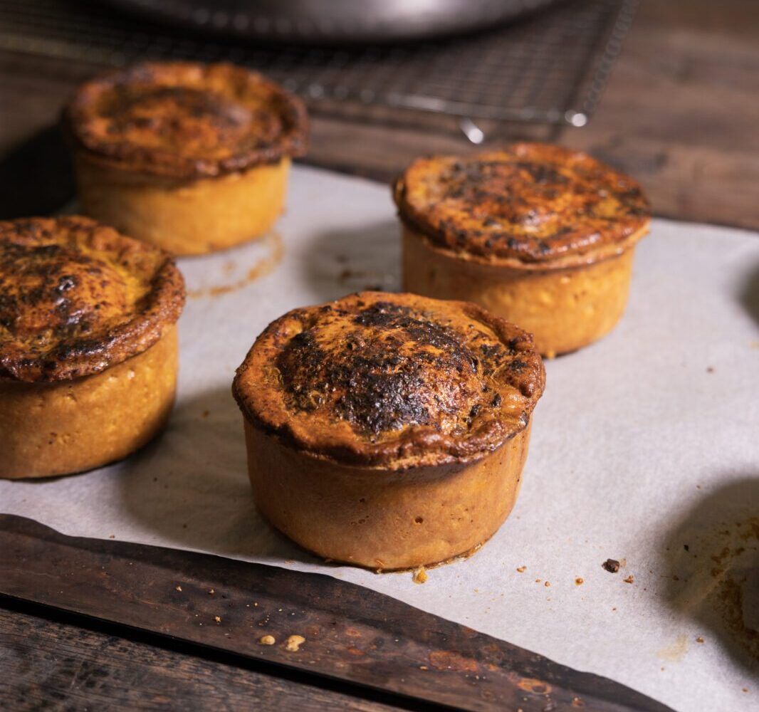 A tray of cooked Wagamama and Willy's Pies chicken katsu curry pies sit on a baking tray fresh out of the oven